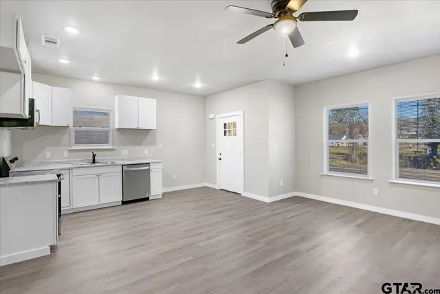 a kitchen with a refrigerator and white cabinets