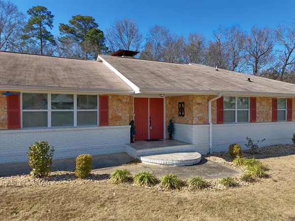 a front view of house with yard and tree in the background
