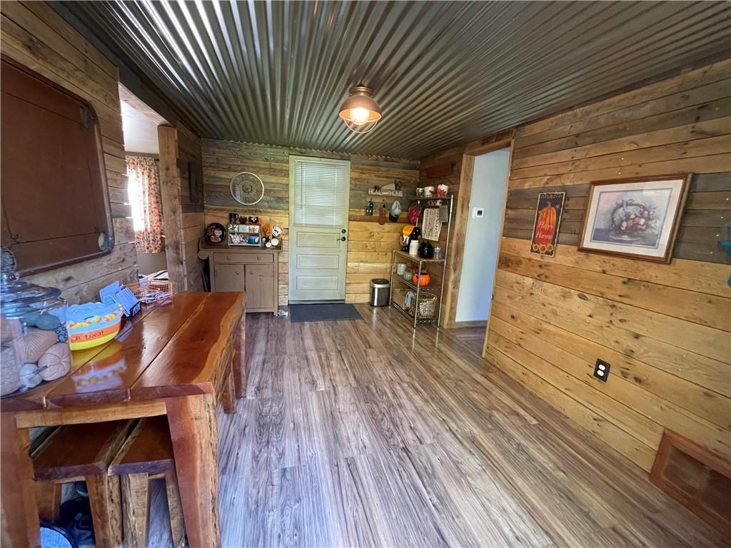 531 Harmony Road Baden, PA 15005 - Photo 6 of 21 Dining room features wood walls, metal ceiling and laminate floor. View is from deck to front door.