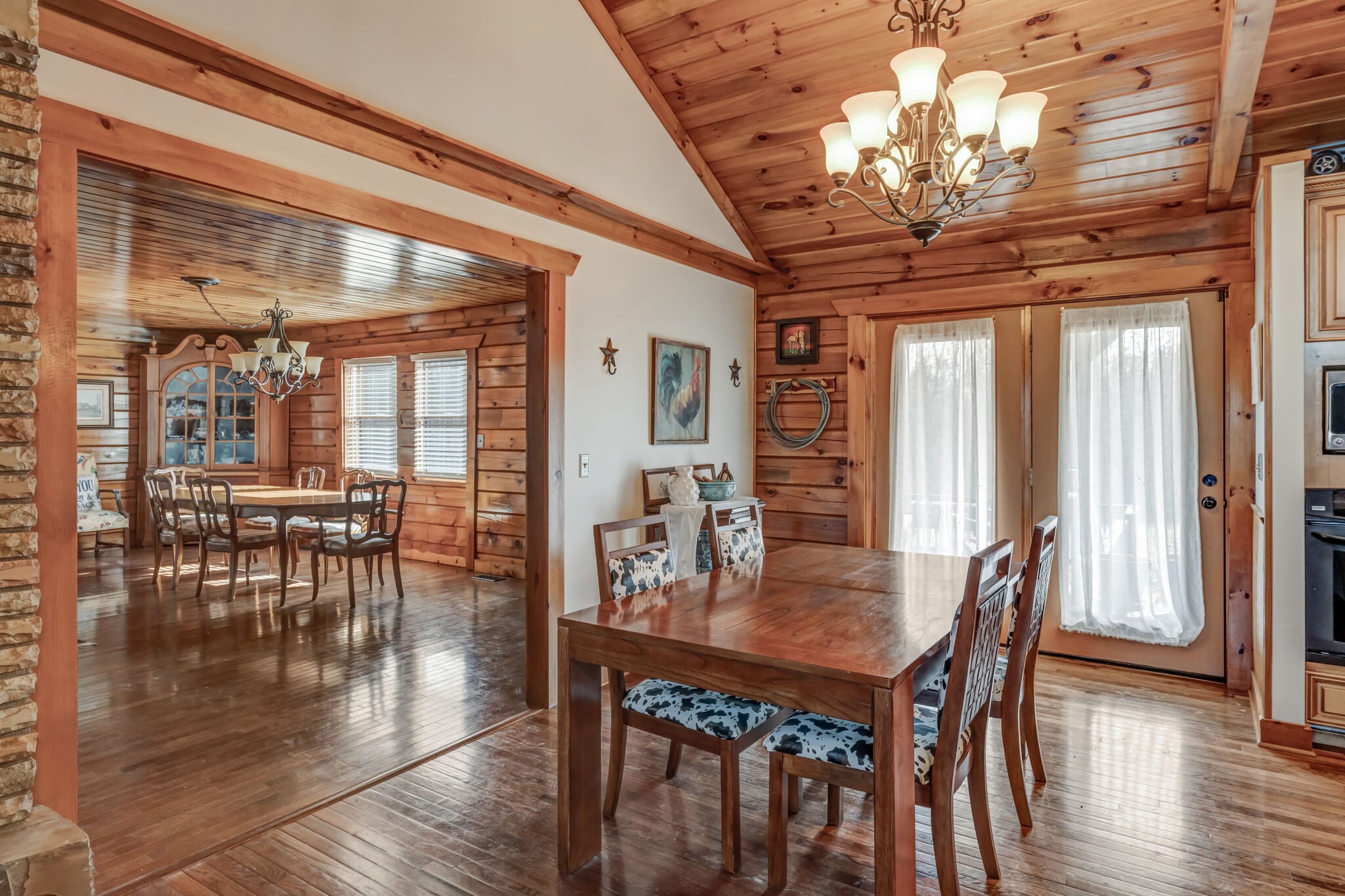 6743 Bethlehem Road Springfield, TN 37172 - Photo 16 of 56 a dining room with wooden floor a chandelier a wooden table and chairs