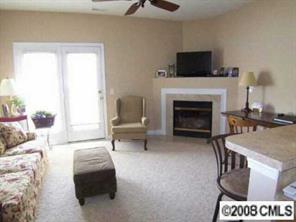 1135 Market Street, Unit 1135 Fort Mill, SC 29708 - Photo 2 of 8 a living room with furniture a flat screen tv and a fireplace