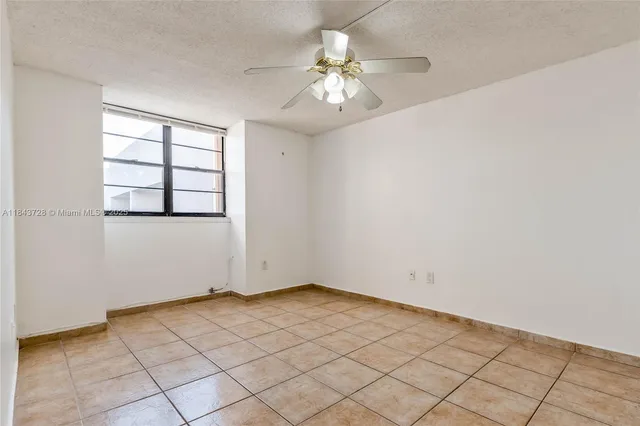 an empty room with windows and ceiling fan