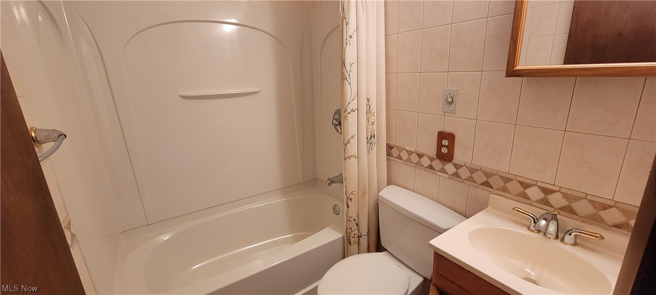 33703 Guilbert Road Eastlake, OH 44095 - Photo 13 of 32 Full bathroom with vanity, bathing tub / shower combination, mirror, and tile walls
