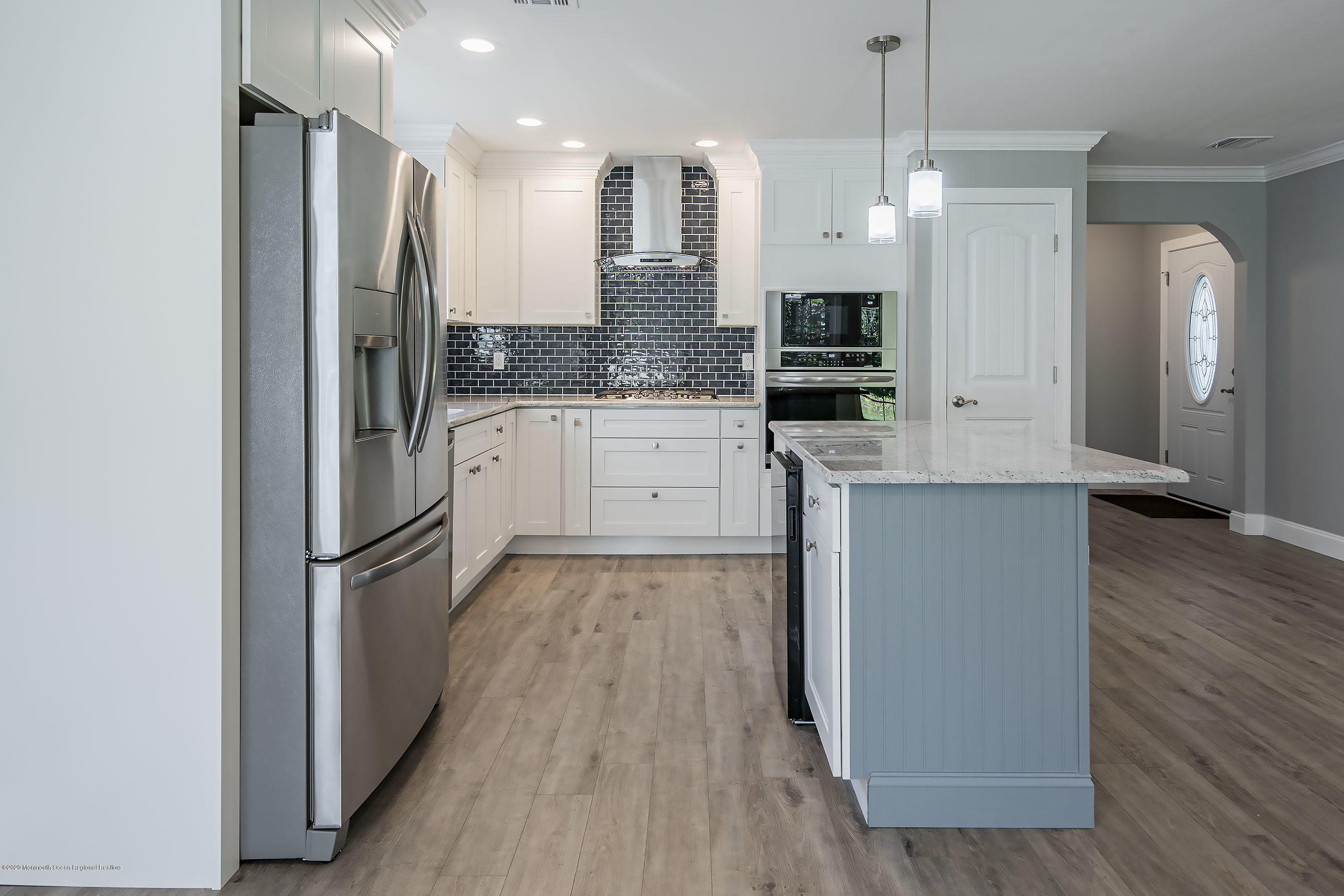 65 Markham Road Brick, NJ 08724 - Photo 9 of 27 a kitchen with stainless steel appliances granite countertop a refrigerator a oven and white cabinets with wooden floors
