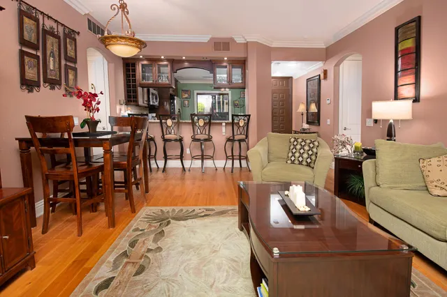 a living room with furniture a dining table and chairs with wooden floor