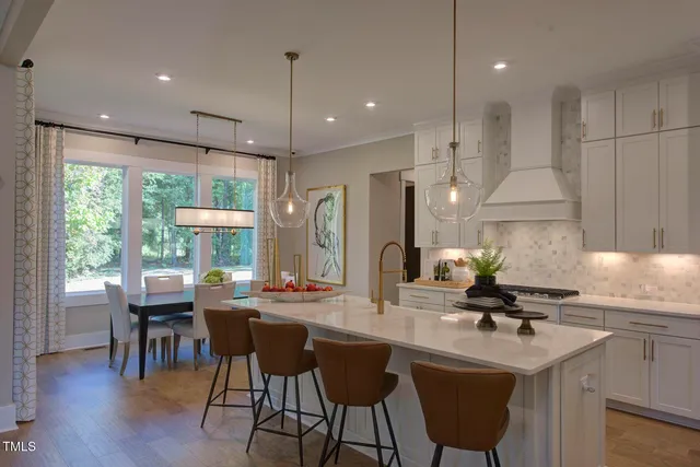 a kitchen with a table chairs refrigerator and microwave