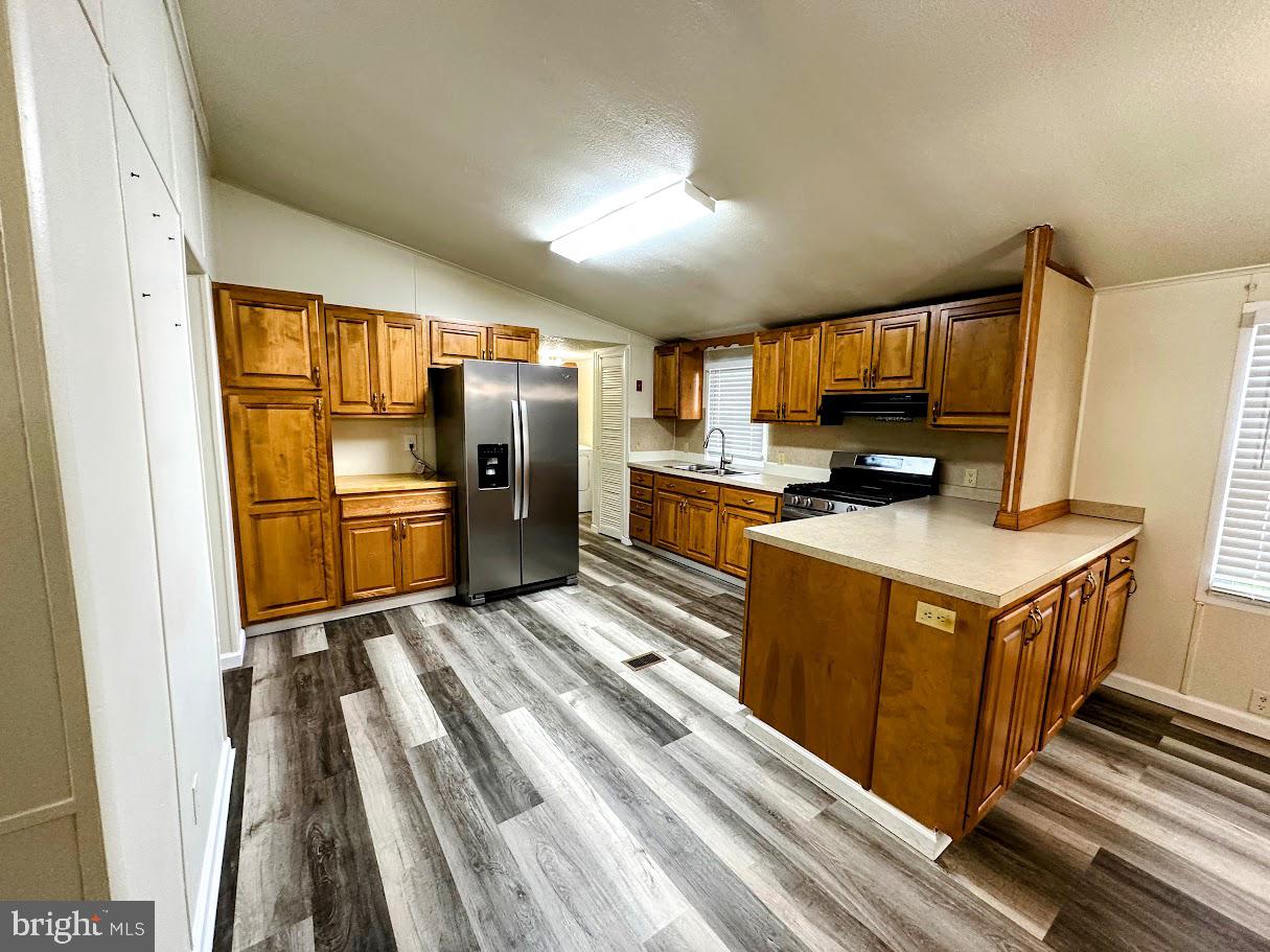 19 Gordon Drive Dover, DE 19901 - Photo 6 of 19 a kitchen with stainless steel appliances granite countertop a refrigerator a stove and a sink with wooden floor