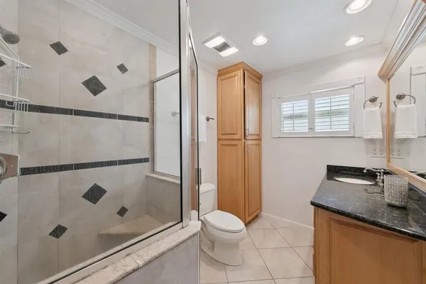 a bathroom with a granite countertop sink a toilet and shower