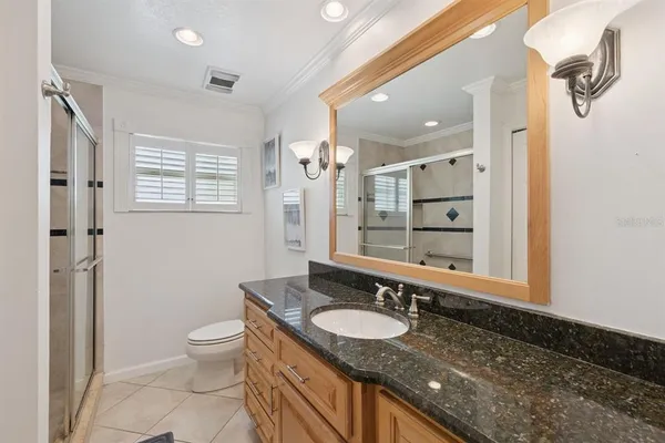 a bathroom with a granite countertop sink toilet and shower