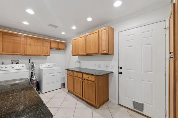 a utility room with cabinets washer and dryer