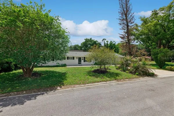 a front view of a house with a yard and a garden