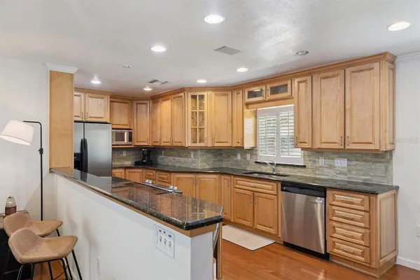 a kitchen with stainless steel appliances granite countertop a sink and cabinets