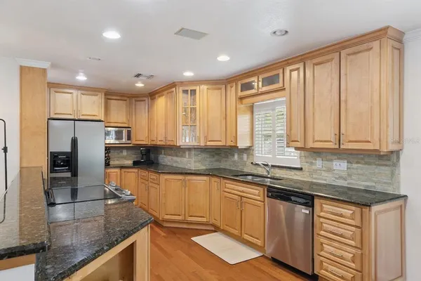a kitchen with stainless steel appliances granite countertop a sink stove and refrigerator