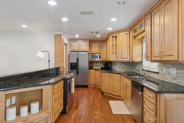 a kitchen with stainless steel appliances granite countertop a stove a sink and a refrigerator