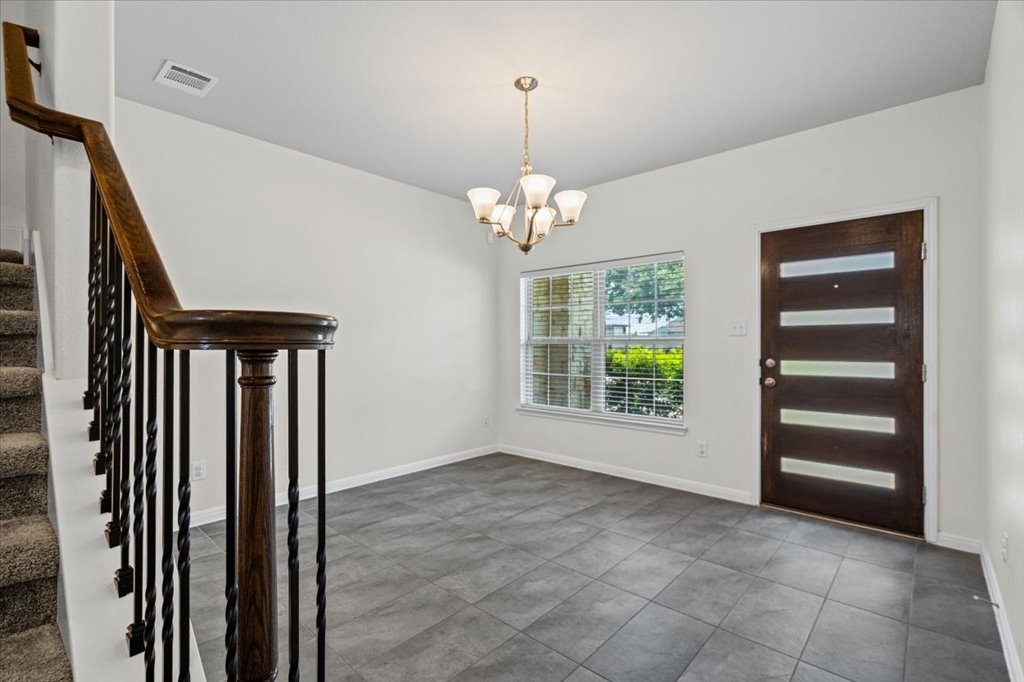 1502 Airedale Road, Unit 2502 Austin, TX 78748 - Photo 6 of 28 A well-lit entry hall with a contemporary front door and inviting staircase, perfect for a grand welcome.