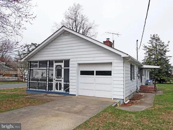 a view of a house with a yard and lawn chairs under wooden roof