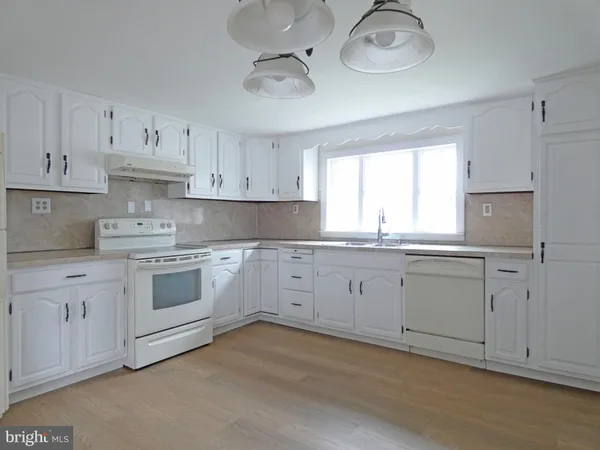 a kitchen with cabinets appliances a sink and a window