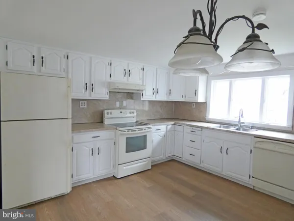 a kitchen with stainless steel appliances granite countertop a sink a stove and white cabinets