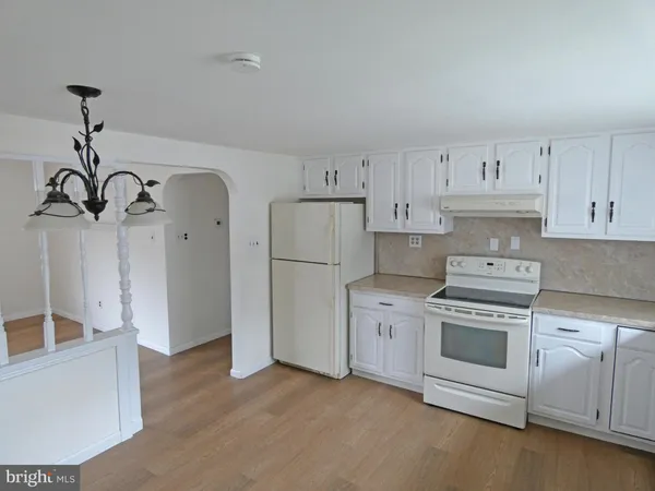 a kitchen with white cabinets and white appliances