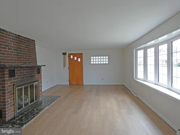 a view of an empty room with a fireplace and a window