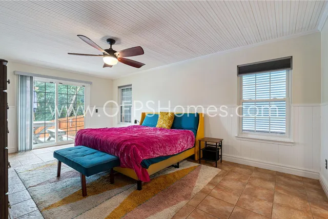 a spacious bedroom with a bed a chandelier and a window