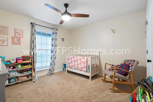 a bedroom with furniture and a chandelier fan