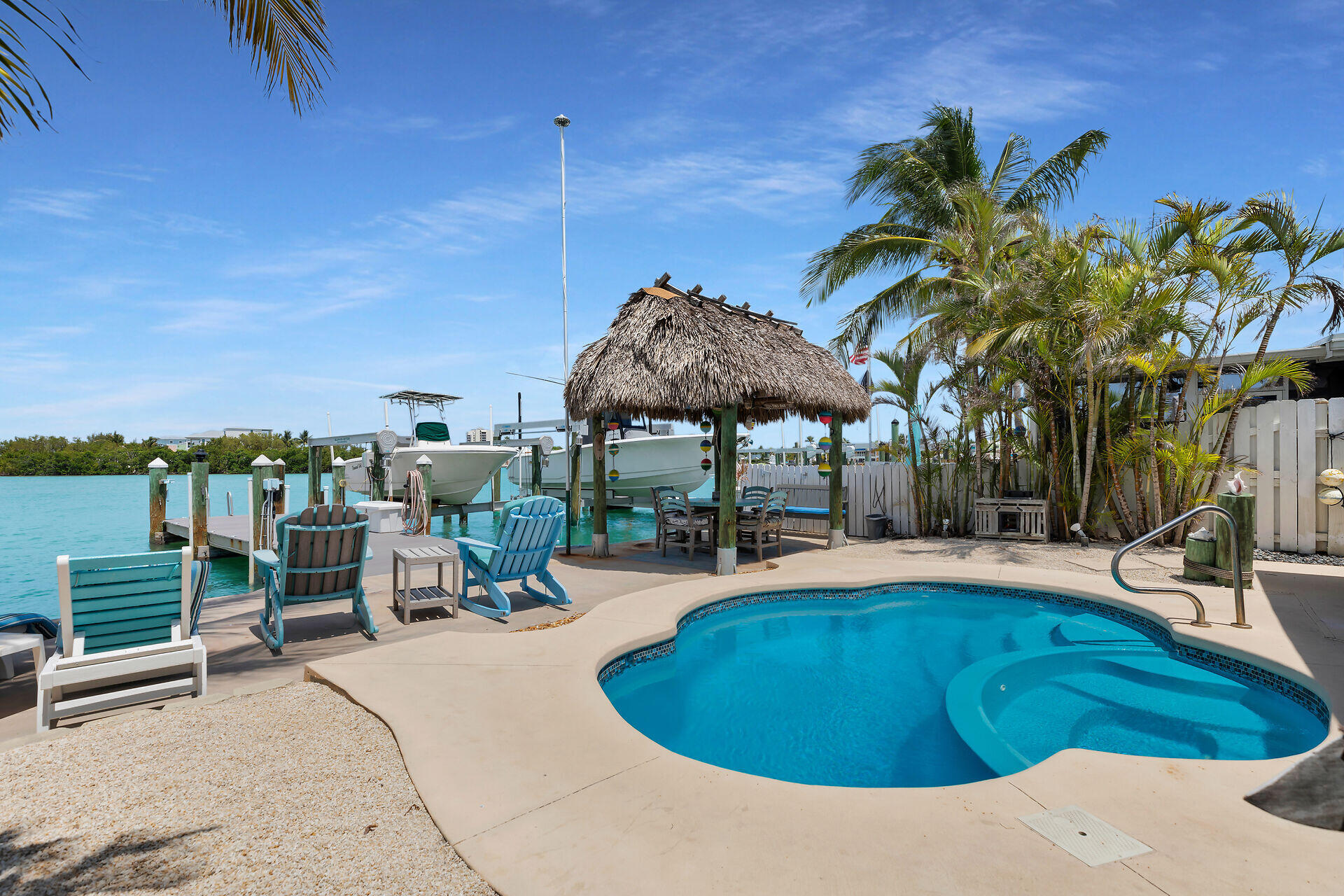 8 Sadowski Key Key Colony Beach, FL 33051 - Photo 25 of 57 a swimming pool with lawn chairs under an umbrella