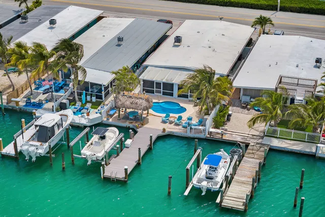 an aerial view of a swimming pool with outdoor seating and yard