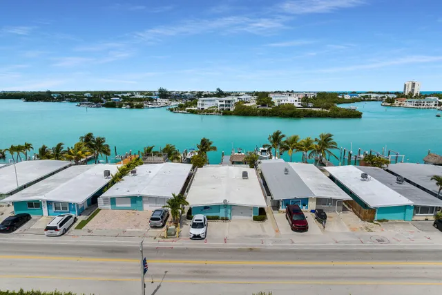 front view of house with a yard and palm trees