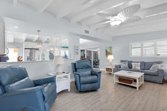 a living room with furniture a chandelier and a wooden floor