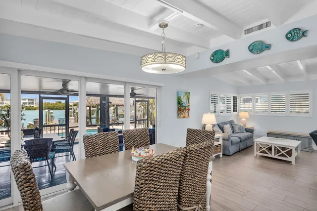 a kitchen with stainless steel appliances granite countertop a stove top oven a dining table and chairs with wooden floor