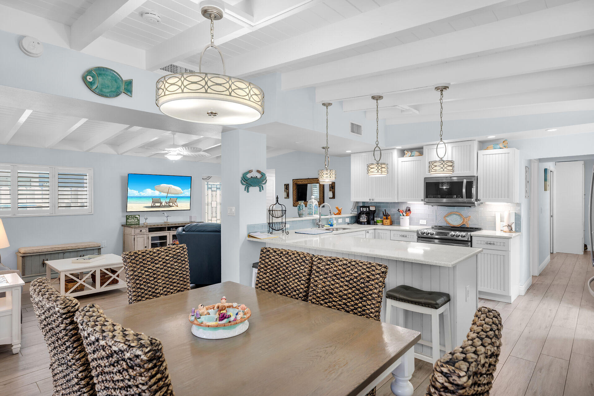 8 Sadowski Key Key Colony Beach, FL 33051 - Photo 7 of 57 a kitchen with stainless steel appliances granite countertop a stove top oven a dining table and chairs with wooden floor