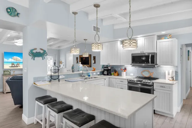 a large kitchen with kitchen island a island a sink a stove and wooden floors
