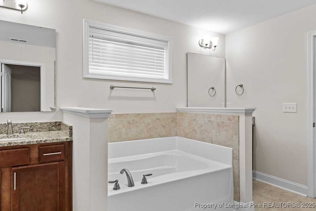 252 School Side Drive Spring Lake, NC 28390 - Photo 26 of 35 a bathroom with a tub sink and mirror