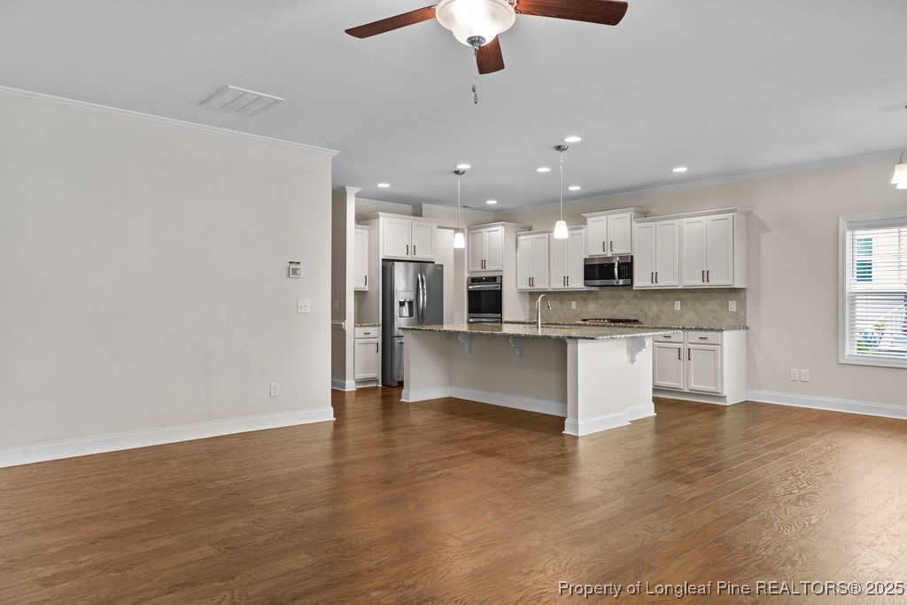 252 School Side Drive Spring Lake, NC 28390 - Photo 8 of 35 a large kitchen with granite countertop a large counter top stainless steel appliances and cabinets