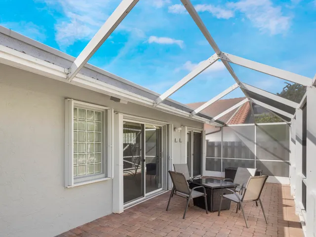 a view of a house with a yard and potted plants