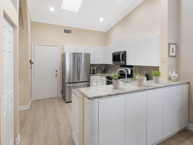 a kitchen with granite countertop a refrigerator and a sink