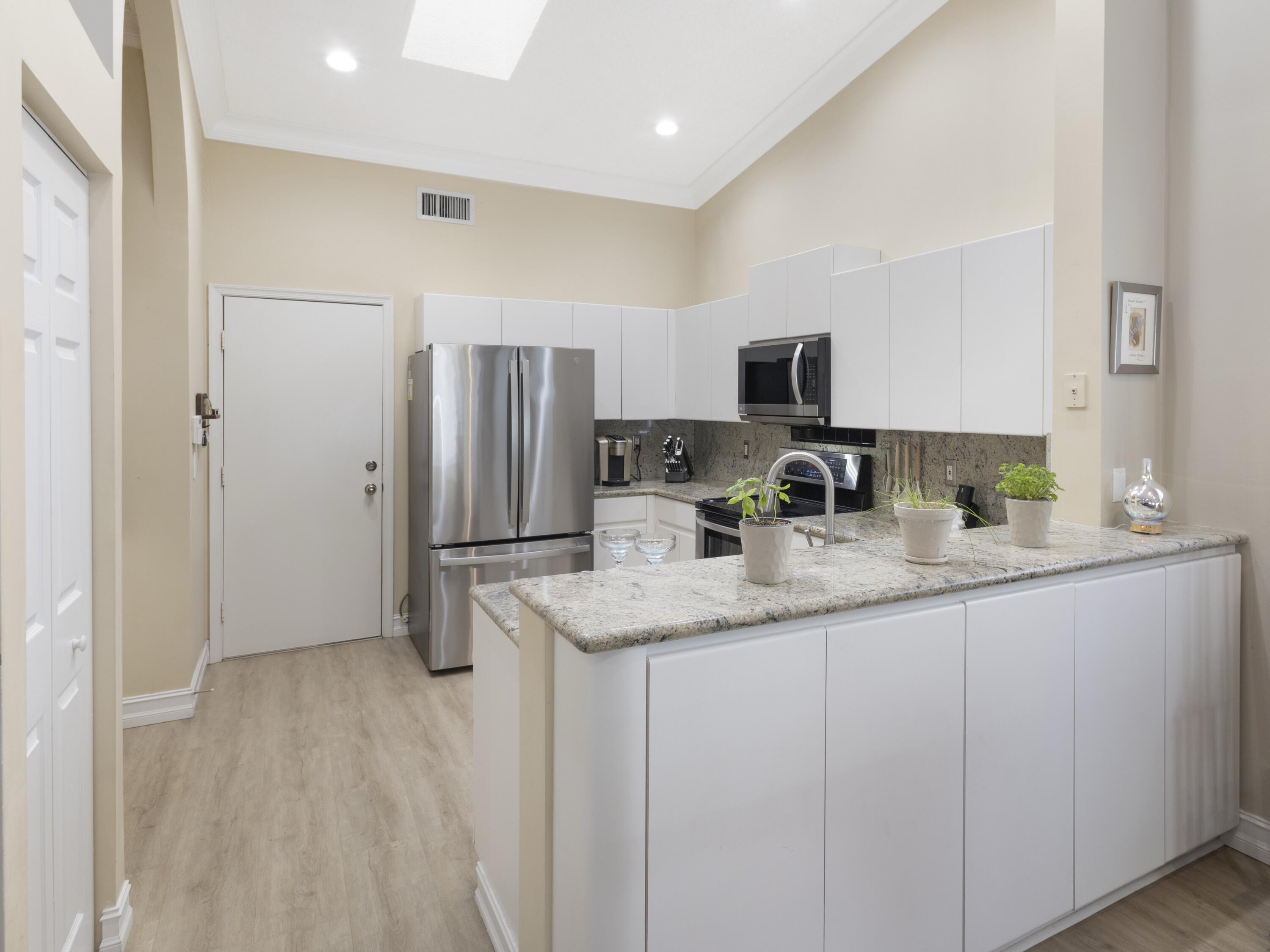 9734 Harbour Lake Circle Boynton Beach, FL 33437 - Photo 6 of 41 a kitchen with stainless steel appliances granite countertop a refrigerator and a stove top oven