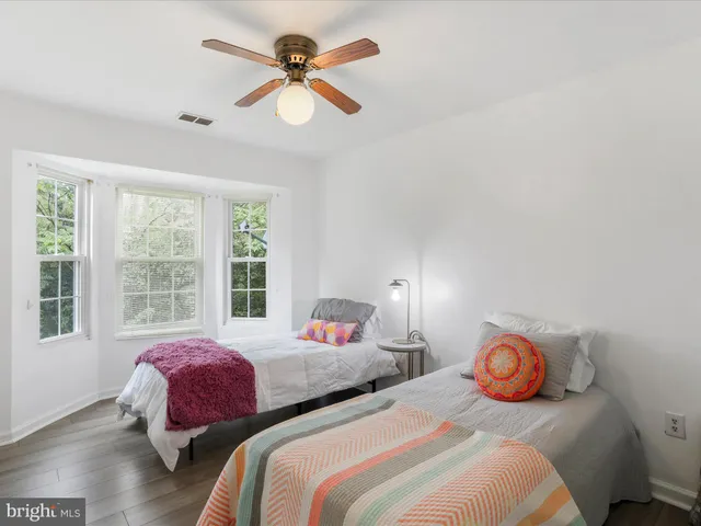 a bedroom with two beds and a large window