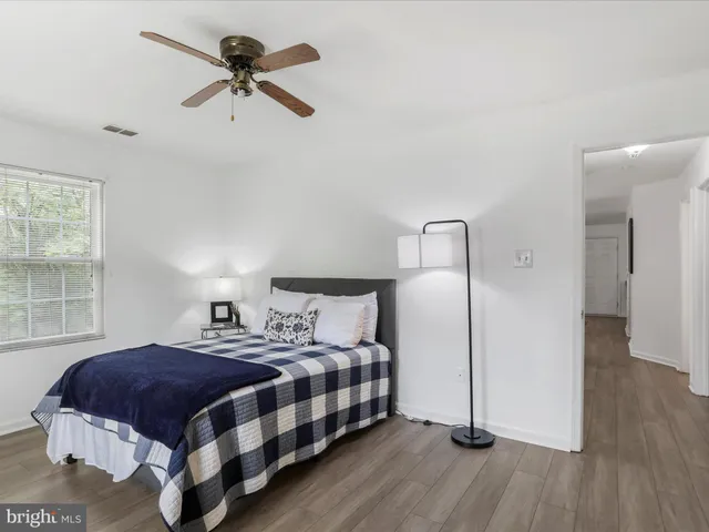 a bedroom with a bed a window and a chandelier