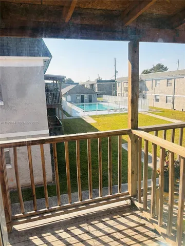 a view of a balcony with a floor to ceiling window and wooden floor