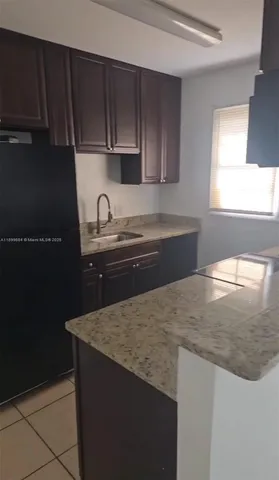 a kitchen with granite countertop a sink and a stove