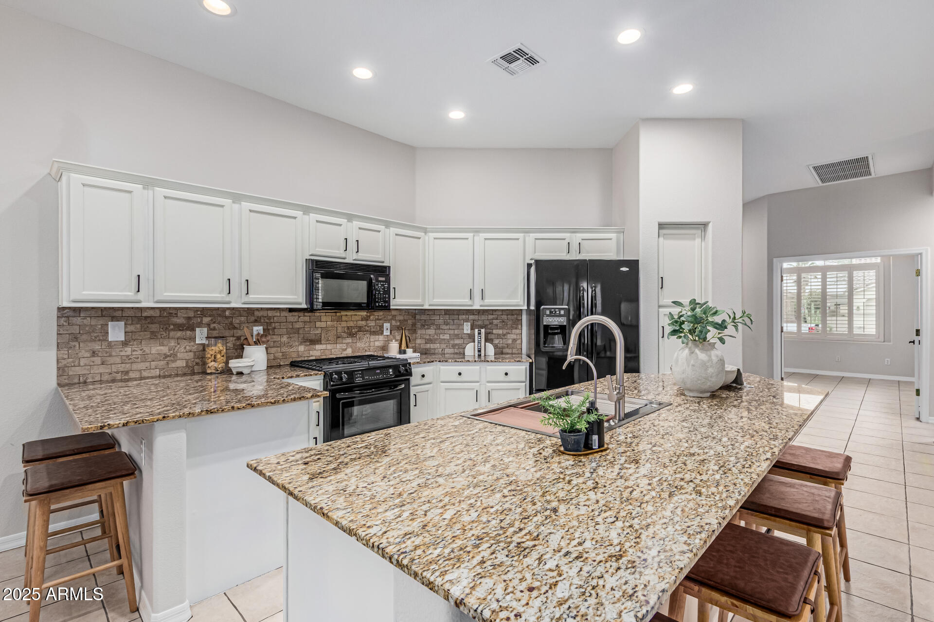 5035 South Ranger Trail Gilbert, AZ 85298 - Photo 10 of 64 a kitchen with kitchen island granite countertop a stove sink and cabinets