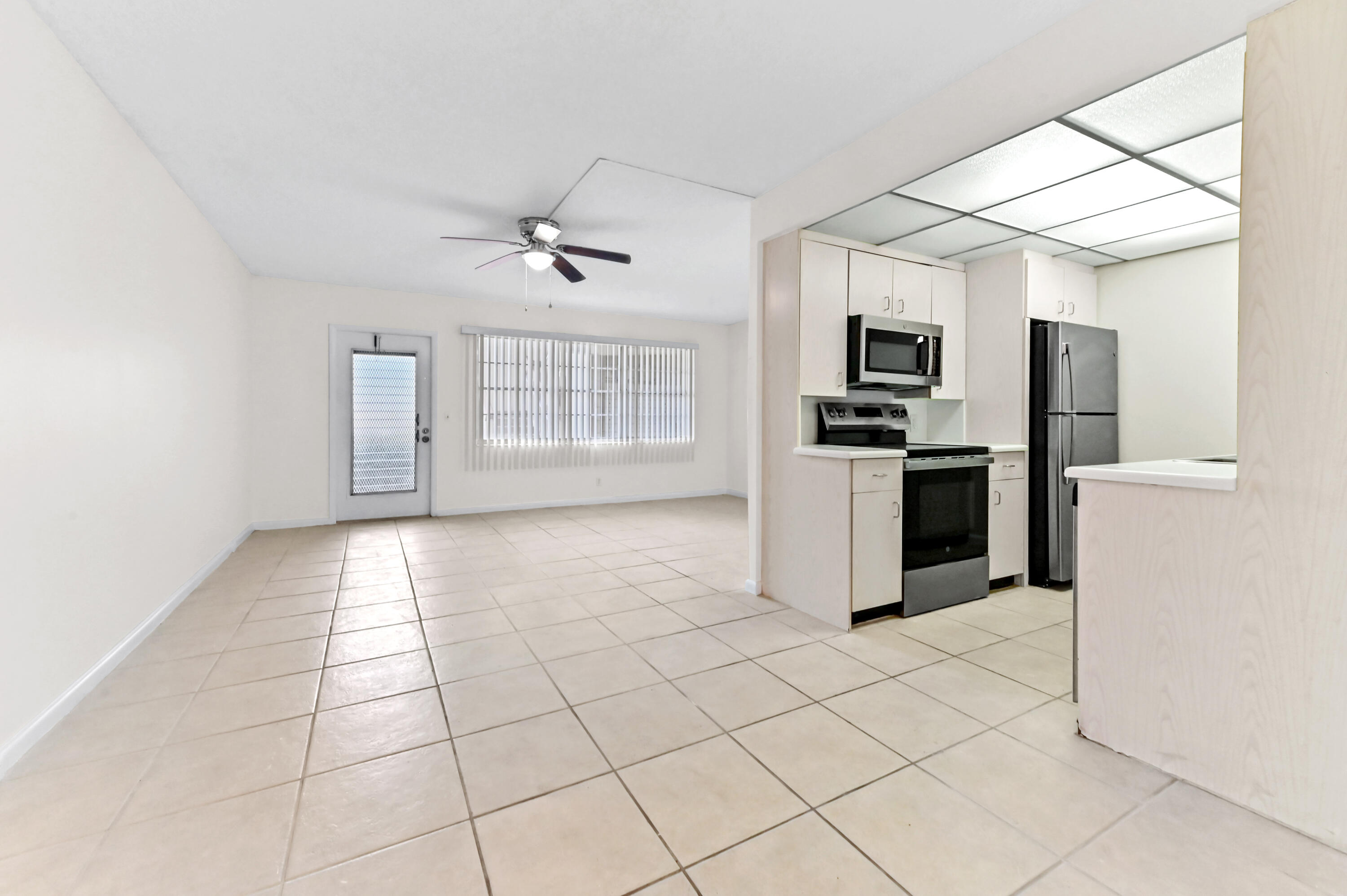 1010 Newcastle A, Unit 1010 Boca Raton, FL 33434 - Photo 2 of 27 a kitchen with stainless steel appliances a refrigerator sink and microwave