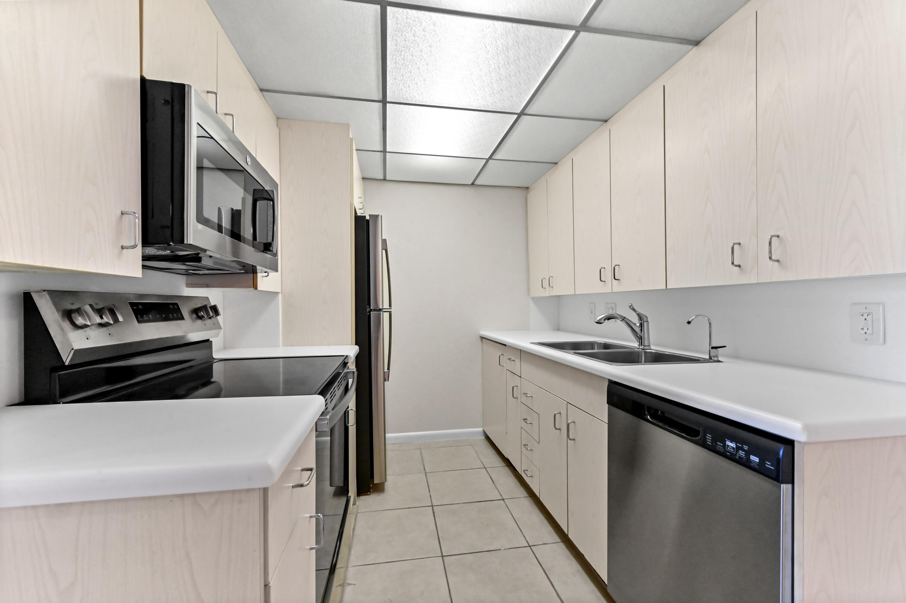 1010 Newcastle A, Unit 1010 Boca Raton, FL 33434 - Photo 5 of 27 a kitchen with stainless steel appliances granite countertop a sink stove and refrigerator