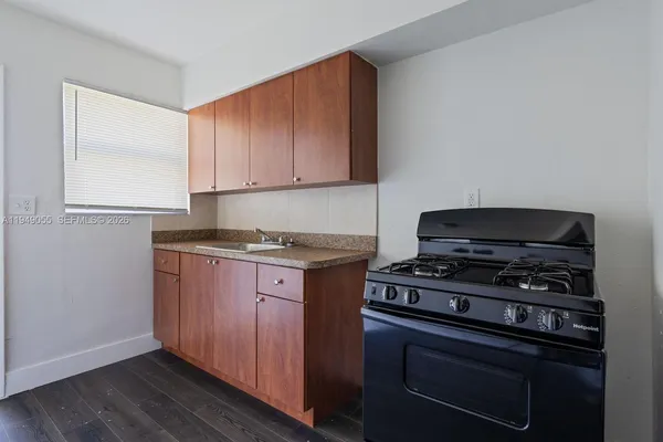 a kitchen with granite countertop a stove and a microwave