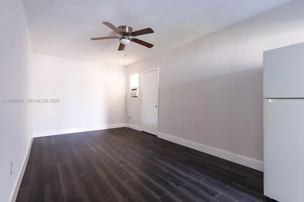 a view of a room with wooden floor and a ceiling fan