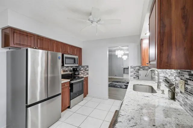 a kitchen with stainless steel appliances granite countertop a refrigerator stove and oven