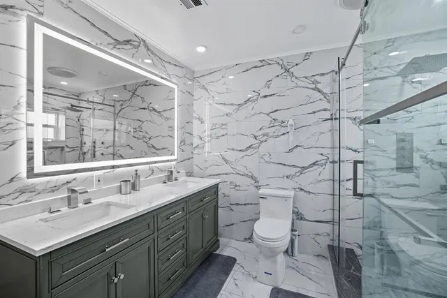 a bathroom with a sink toilet vanity and shower