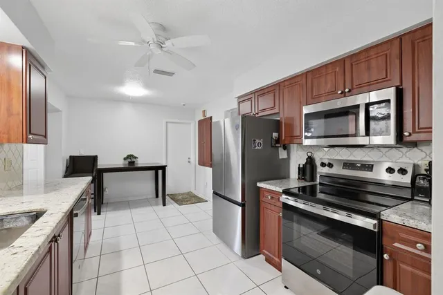 a kitchen with stainless steel appliances granite countertop a stove microwave and refrigerator